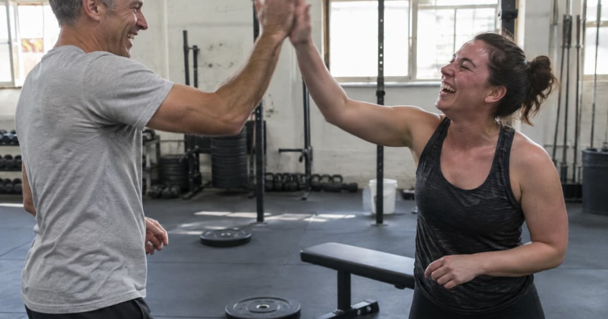 A coach and his client high-fiving after a successful set